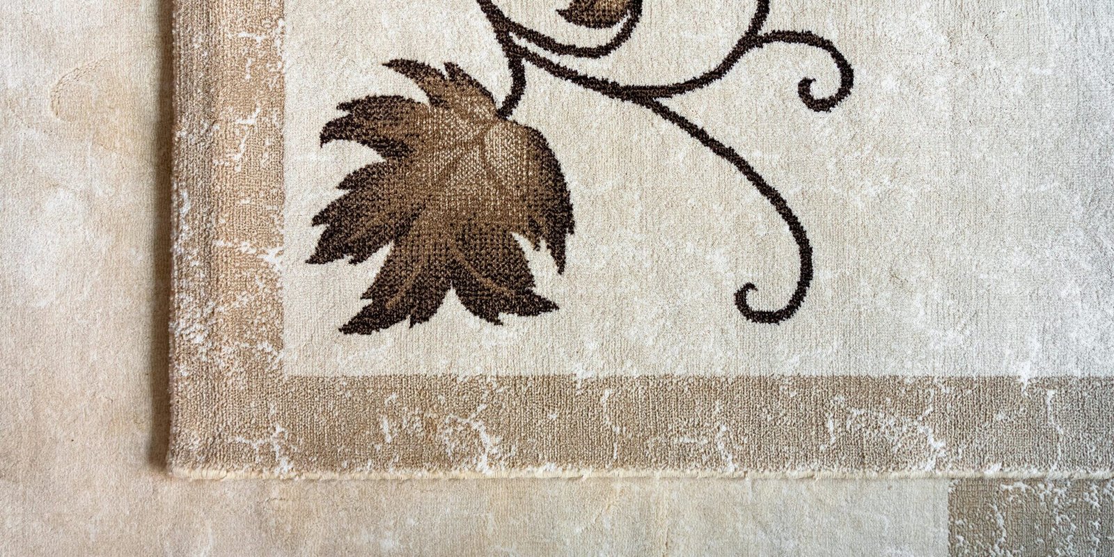 Home Close-up of an elegant floral pattern on a textured beige rug enhancing interior decor.